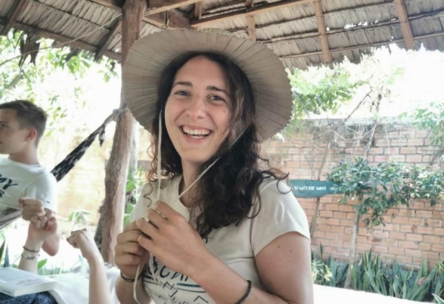 Hélène au Cambodge avec un chapeau de paille sous une paillote