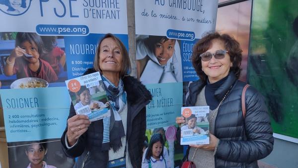 Deux bénévoles de l'opération mini-don à Chatou, montrent le flyer distribué aux clients