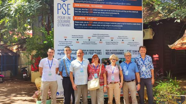 Equipe de bénévoles suisse devant le panneau à l'entrée de PSE