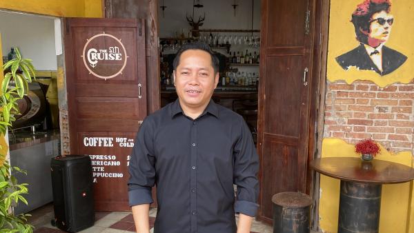 Leng, a former PSE student, in front of his café in Kampot