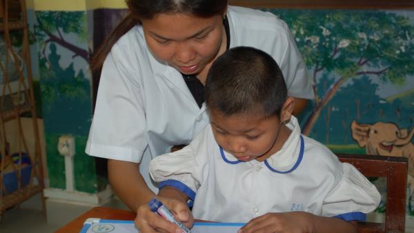 A special educator helps a child with a disability