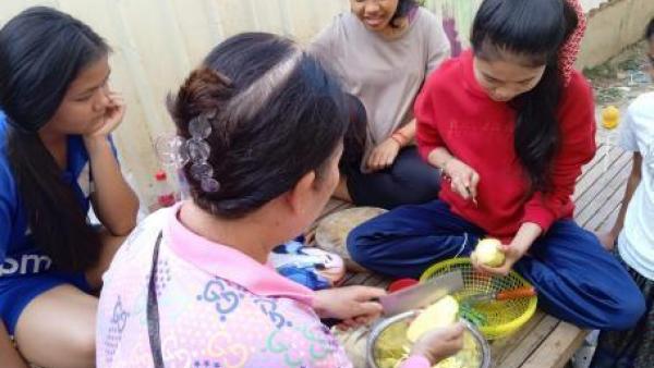 Karuna cuisine avec sa mère d'accueil et d'autres jeunes pris en charge avec elle