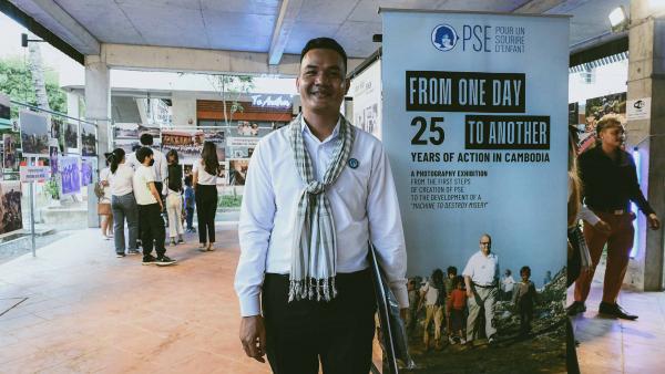 Un ancien élève de PSE pose devant l'entrée de l'exposition photo à PSE
