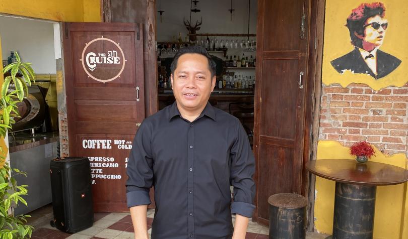 Leng, a former PSE student, in front of his café in Kampot