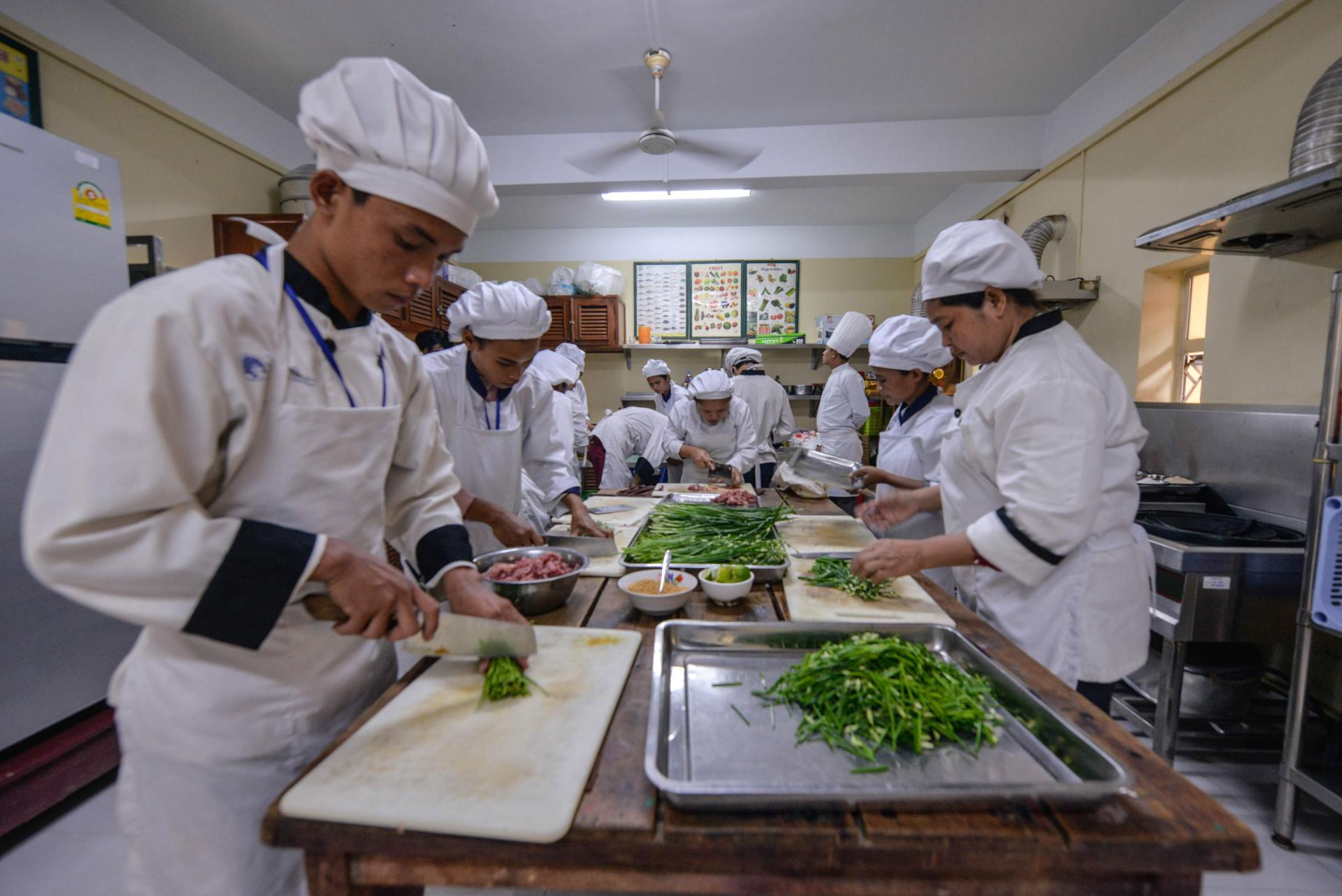 Des jeunes en formation professionnelle courte de cuisine en train de cuisiner