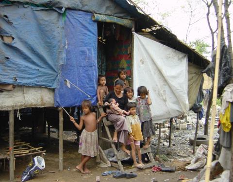 Une famille devant sa maison faite de tôles dans une communauté Une famille devant sa maison faite de tôles dans une communauté